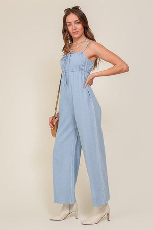 DENIM BLUE SLEEVELESS JUMPSUIT WITH SELF FRONT TIE Lumiere 